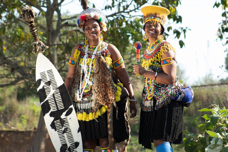 Two women dressed in colorful traditional Zulu attire, showcasing rich cultural heritage outdoors in KZN.