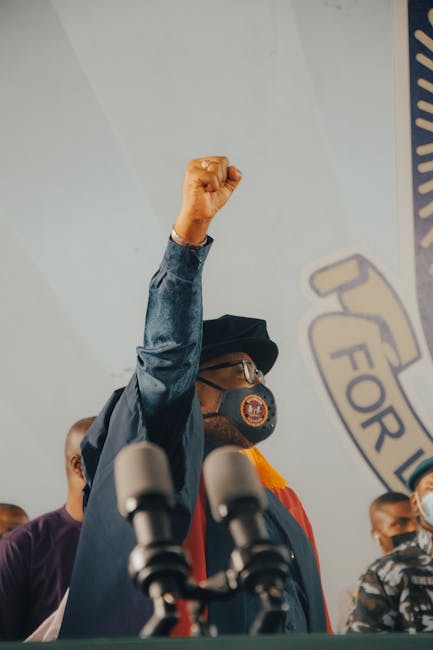 A man in Nigeria raising a fist during a speech at a press conference.
