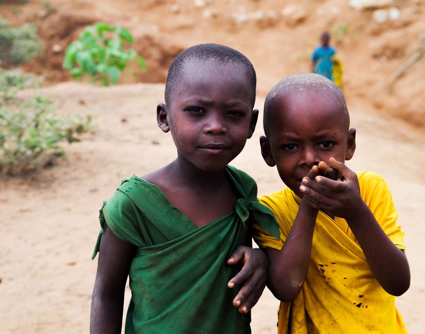Close-up of two children in vibrant clothing on a dirt road in Tanzania.