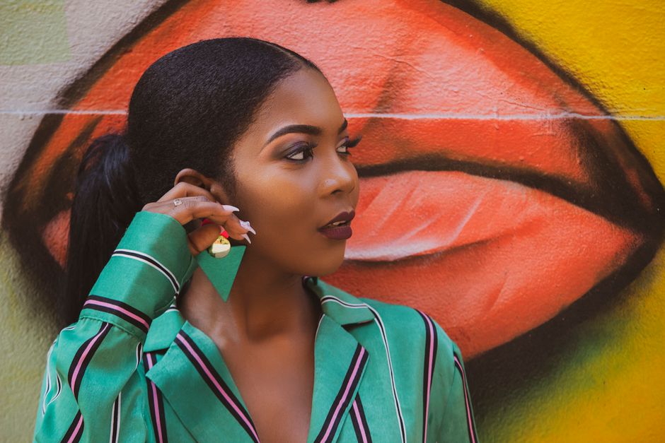 Elegant woman posing against vibrant graffiti wall in Angola.